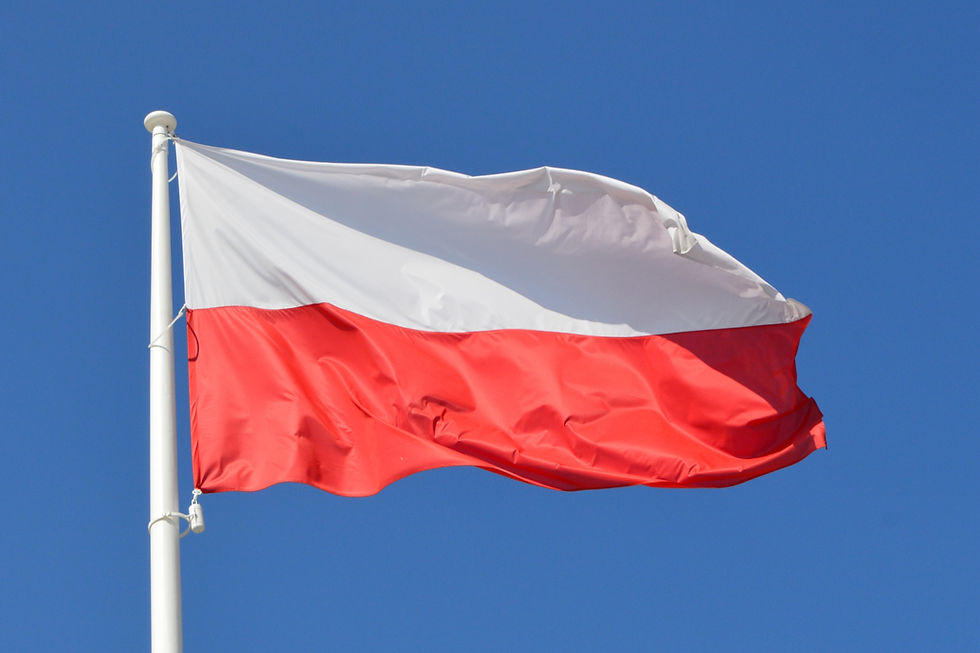 Red and white flag waving against clear blue sky, attached to a white pole. The scene conveys a sense of national pride and calm.