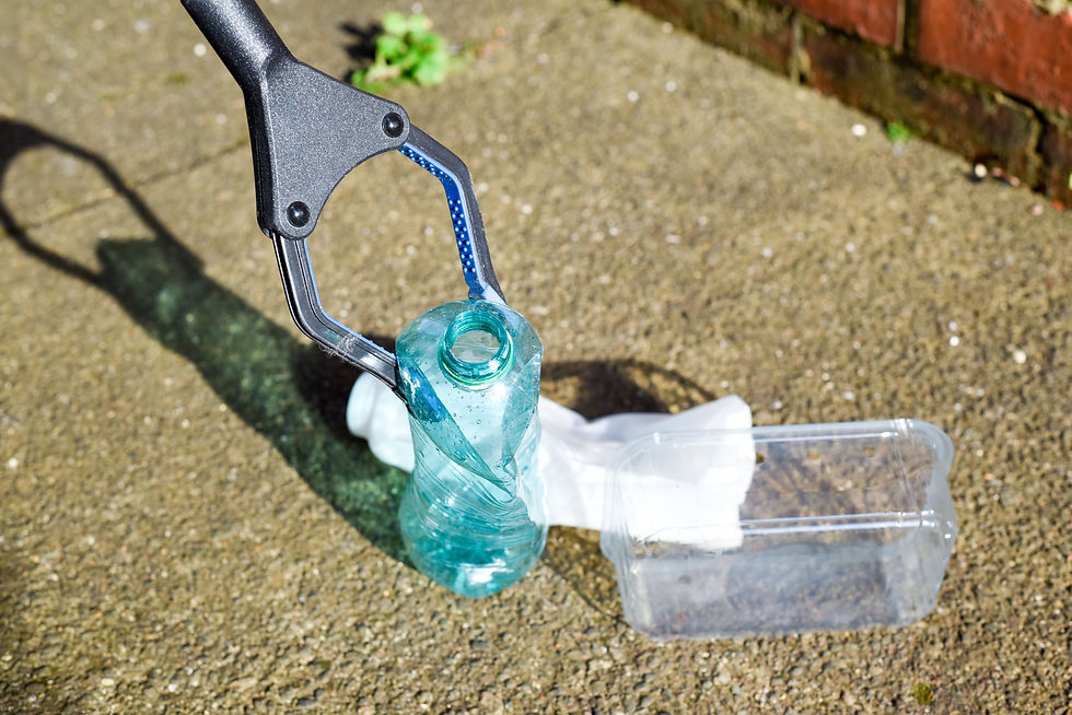 Litterpicker picking up plastic bottles and tupperware fromground