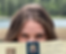Photo of Bethany Beaulaurier with her blue eyes peeking above the book Pride and Prejudice by Jane Austen. Green tress blurred in background.