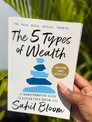 The 5 Types of Wealth by Sahil Bloom book cover outdoors held nature plants
