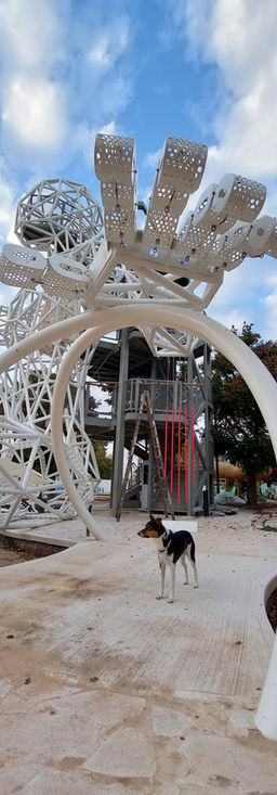 Close-up of white steel lattice sculpture with visitors