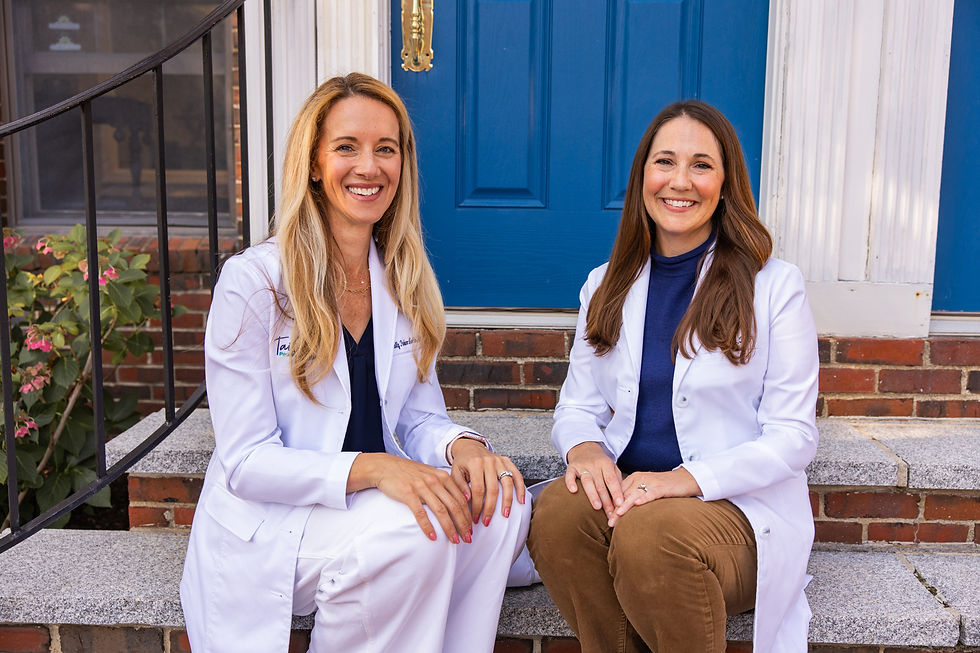 The doctor and nurse pose smiling at the camera