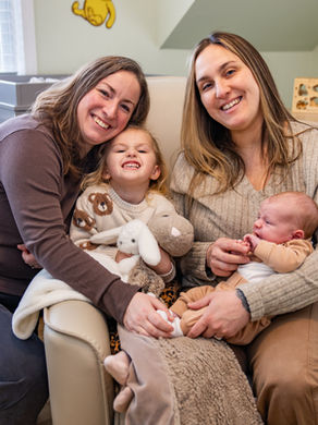 family posing in the nursery with their new baby