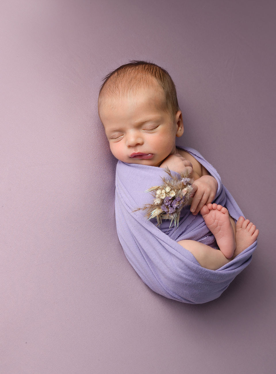baby girl with a bunch of flowers photographed by Newborn photographer Dromore