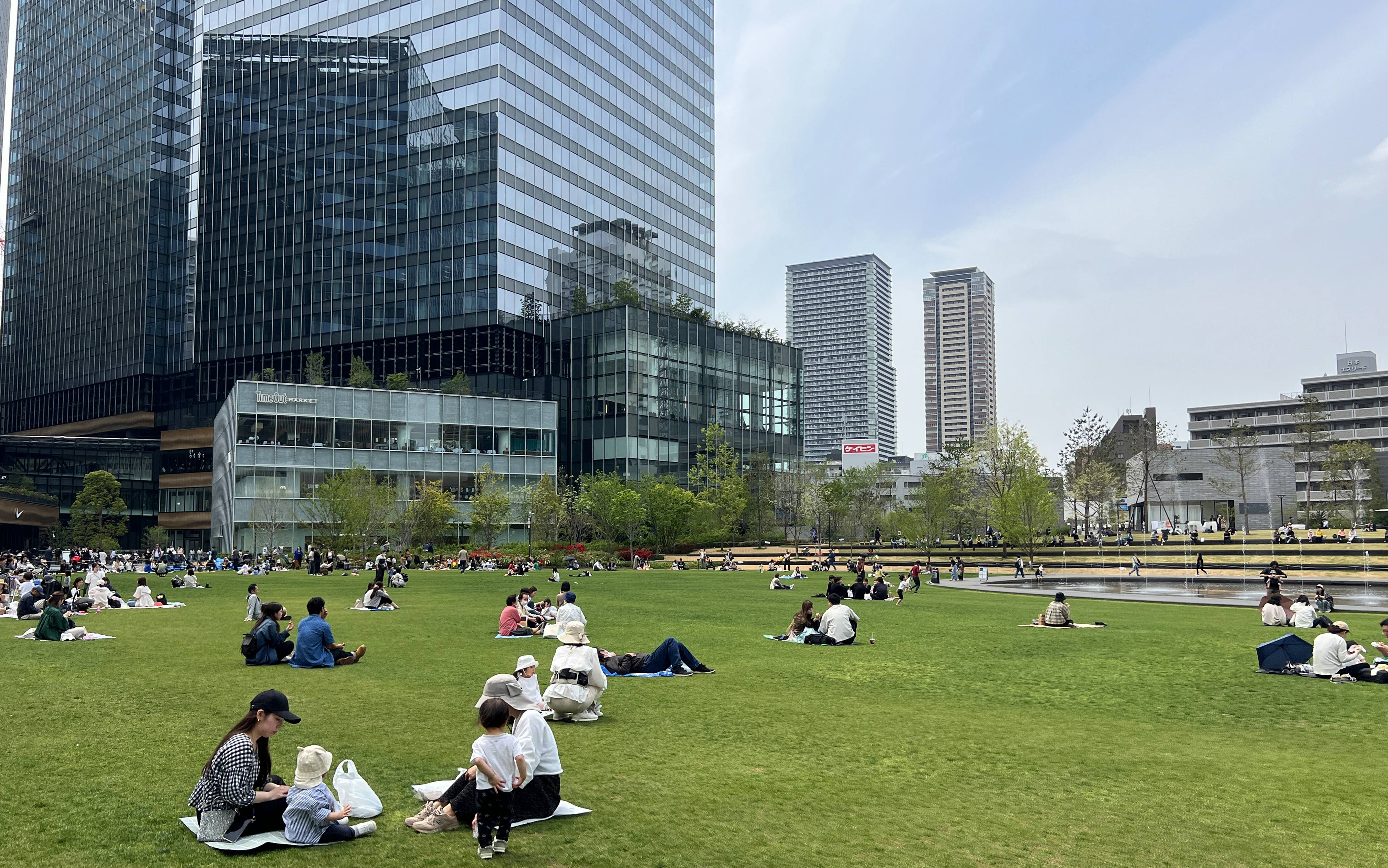 城市綠地上有許多人們在草地上野餐休息