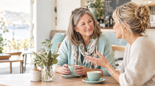 Two women in their 50s sharing a coffee and listening to each other