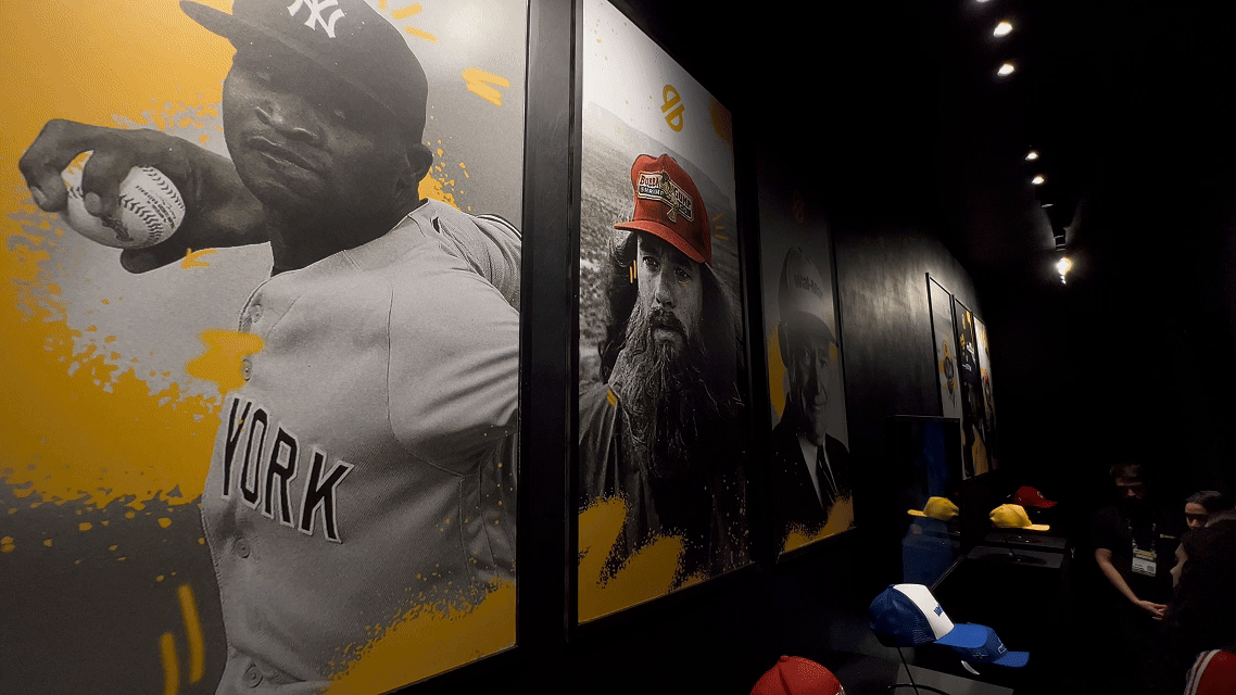 Visitantes interagem com o Museu RFID do Seu Boné na Brazil Promotion 2025, posicionando bonés históricos com tags RFID sobre suporte personalizado produzido em impressoras 3D pela Phygital Solutions, revelando histórias e curiosidades em tempo real.