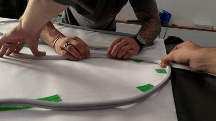 Autorama LED Phygital com traçado iluminado, controles 3D e pista personalizada. Participantes configuram clima e horário da corrida antes da largada.