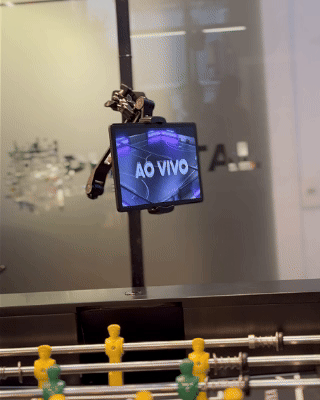 Mesa de Pebolim AI Phygital em ambiente de evento, com visual esportivo inspirado na Copa do Mundo e experiência interativa com inteligência artificial.