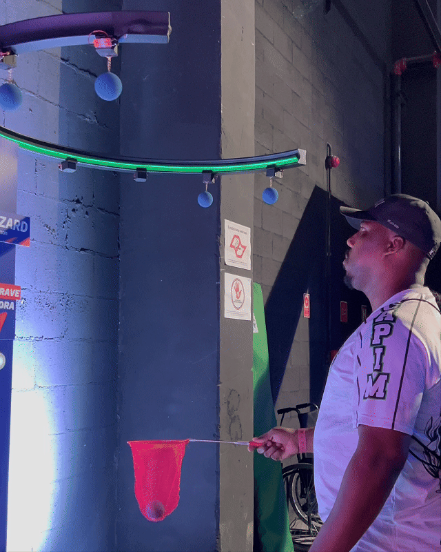 Participante interagindo com o Reaction Ring na Kings League Brazil, ativação desenvolvida pela Phygital Solutions em parceria com a Wizard e a agência Arsenal, onde reflexos e agilidade são testados em uma dinâmica interativa com estímulos luminosos em tempo real.