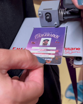 Pessoa interagindo com totem digital em loja da Vivo, realizando cadastro e tirando foto para geração de card personalizado impresso na hora durante ação pré-Lollapalooza.