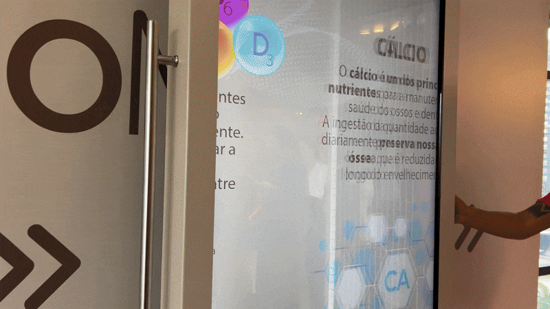 Participantes interagem com a tela Raio X da Phygital Solutions no evento de lançamento do AminoMov da Ajinomoto, explorando de forma dinâmica os benefícios do suplemento.