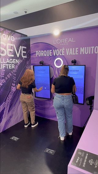 Ativação interativa da L’Oréal com totem digital capturando vídeo em slow motion para registrar transformação de cabelo durante experiência em shopping.