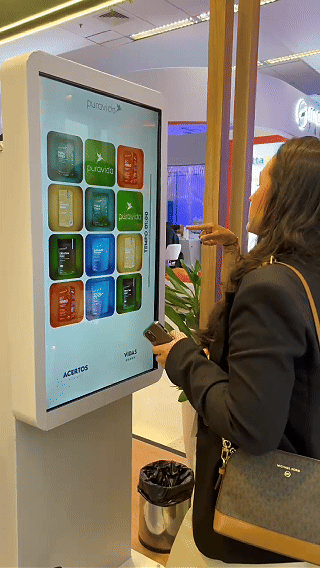 Imagem do estande Puravida no Congresso de Nutrologia, com visitantes participando do jogo da memória digital desenvolvido pela Phygital Solutions.