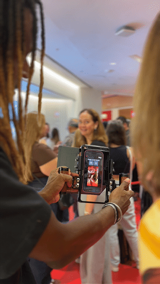 Participantes interagem com ativação Câmera Sign durante a inauguração da loja H&M no Shopping Rio Sul, criando vídeos personalizados com assinatura digital diretamente na lente da câmera.