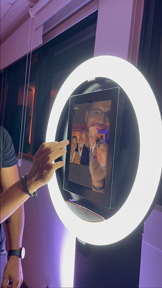 Totem Capture Booth instalado no evento de Centenário do St. Paul’s School, com participante posando para foto e impressão instantânea 10x15 sendo realizada no local.