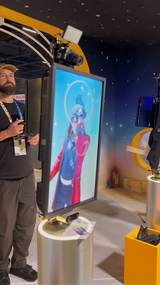 Visitantes interagem na ativação Pokémon Company | BGS 2025 – Experiência Megaevolução. Totens digitais da Phygital Solutions exibem o processo de escolha do Pokémon e da Mega Evolução, com público participando, cartões personalizados e iluminação temática do estande.