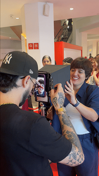 Participantes interagem com ativação Câmera Sign durante a inauguração da loja H&M no Shopping Rio Sul, criando vídeos personalizados com assinatura digital diretamente na lente da câmera.