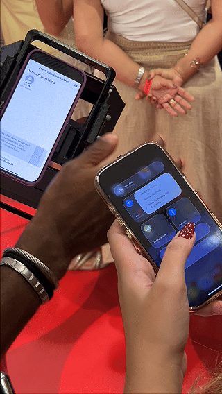 Participantes interagem com ativação Câmera Sign durante a inauguração da loja H&M no Shopping Rio Sul, criando vídeos personalizados com assinatura digital diretamente na lente da câmera.