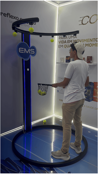 Ativação Reaction Ring no espaço da EMS durante o RIO OPEN 2026, com participante dentro da estrutura semicircular interativa enquanto o público acompanha ao redor em ambiente de evento esportivo.