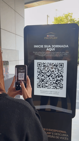 Totem interativo da ativação Nestlé Purina com QR Code para envio de fotos pelo celular. A experiência utilizava inteligência artificial para gerar uma imagem personalizada do tutor ao lado do seu pet, com resultado final direcionado para impressão.