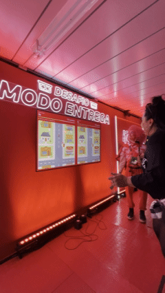 Visitantes jogam Modo Entrega e Duelo Mercado no Stand Bar do iFood, com tablets controlando estoque e prêmios.