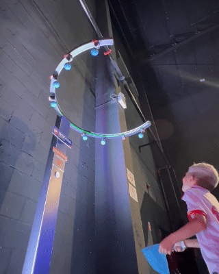 Participante interagindo com o Reaction Ring na Kings League Brazil, ativação desenvolvida pela Phygital Solutions em parceria com a Wizard e a agência Arsenal, onde reflexos e agilidade são testados em uma dinâmica interativa com estímulos luminosos em tempo real.