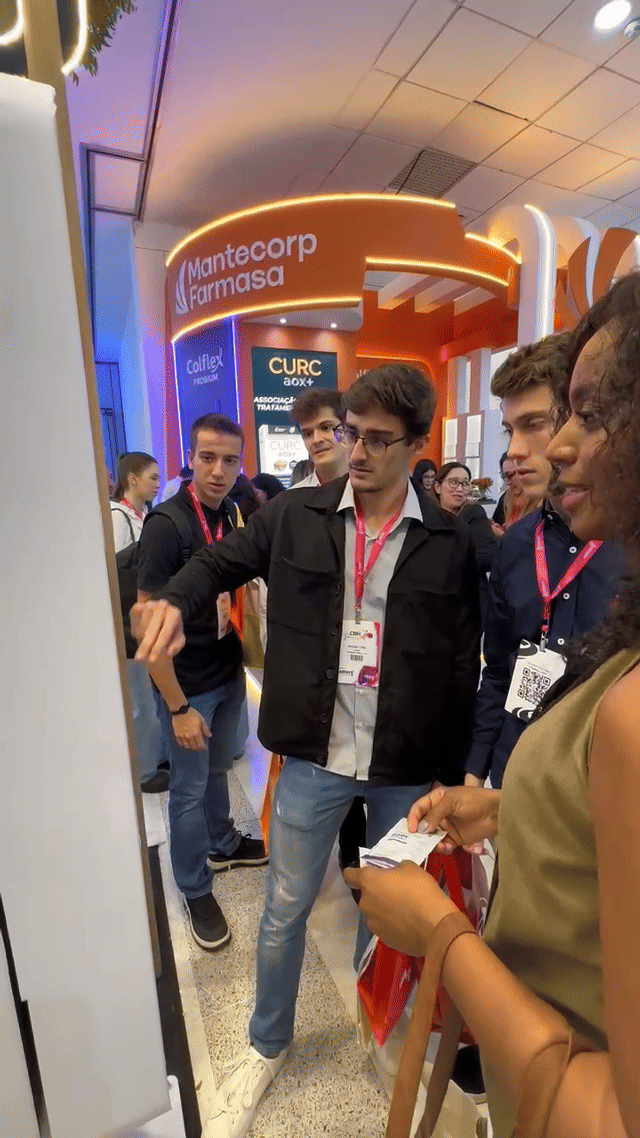 Imagem do estande Puravida no Congresso de Nutrologia, com visitantes participando do jogo da memória digital desenvolvido pela Phygital Solutions.