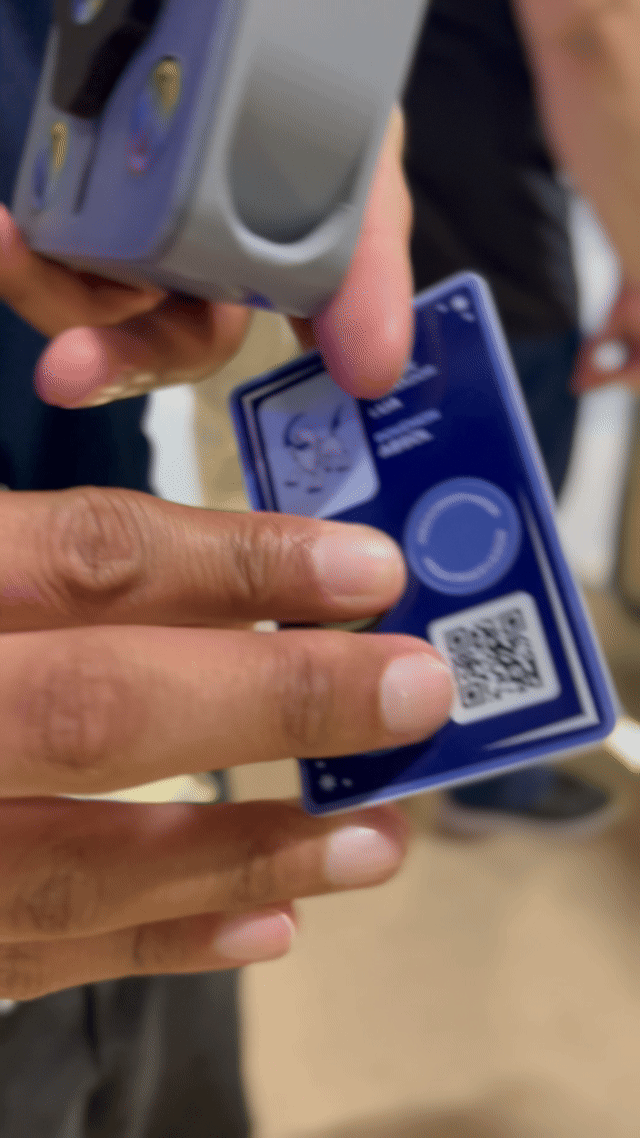 Visitantes interagem na ativação Pokémon Company | BGS 2025 – Experiência Megaevolução. Totens digitais da Phygital Solutions exibem o processo de escolha do Pokémon e da Mega Evolução, com público participando, cartões personalizados e iluminação temática do estande.