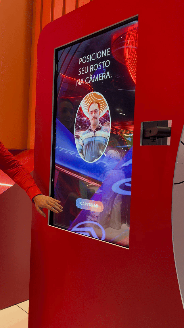Visitante sendo fotografado em um totem da Citroën no Salão do Automóvel 2025, tendo sua imagem transformada por IA em um piloto da Fórmula E. A foto final aparece na tela ao lado, enquanto outro participante interage com a Roleta Digital personalizada com identidade da marca.