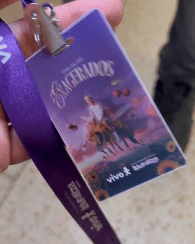 Pessoa interagindo com totem digital em loja da Vivo, realizando cadastro e tirando foto para geração de card personalizado impresso na hora durante ação pré-Lollapalooza.