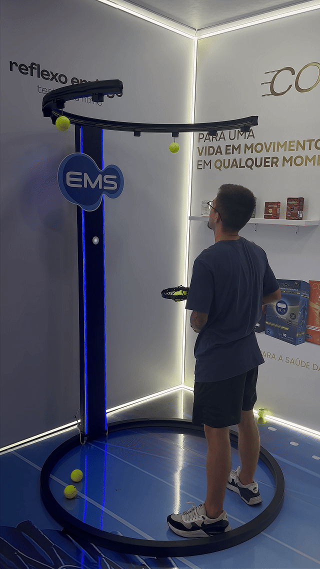 Ativação Reaction Ring no espaço da EMS durante o RIO OPEN 2026, com participante dentro da estrutura semicircular interativa enquanto o público acompanha ao redor em ambiente de evento esportivo.