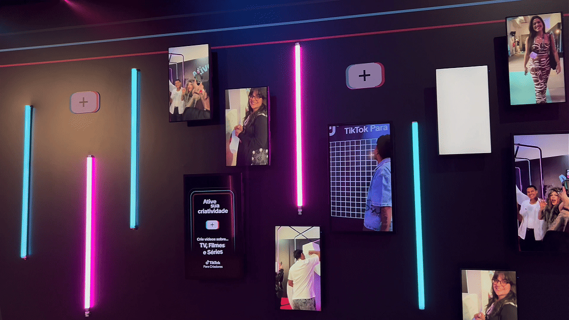 Participantes do evento TikTok para Criadores 2025 interagem com Roaming Booths da Phygital Solutions; vídeos gravados são exibidos em looping em uma Social Wall, criando engajamento contínuo durante o evento no Komplexo Tempo.