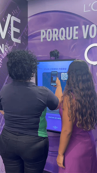 Ativação interativa da L’Oréal com totem digital capturando vídeo em slow motion para registrar transformação de cabelo durante experiência em shopping.