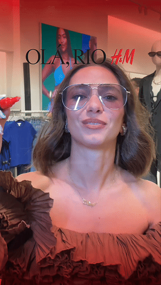Participantes interagem com ativação Câmera Sign durante a inauguração da loja H&M no Shopping Rio Sul, criando vídeos personalizados com assinatura digital diretamente na lente da câmera.