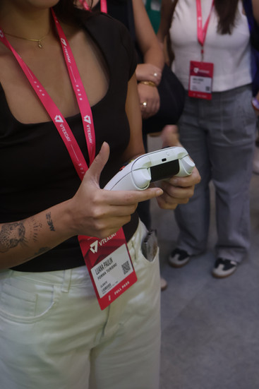 Participante joga ativação interativa da 99Entrega em um totem com joystick durante o VTEX DAY 2026, navegando em um labirinto estilo game para realizar entregas virtuais.