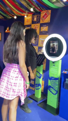 Participante tira foto no AI Booth da Santa Helena durante a Festa Junina do Clube Pinheiros e recebe imagem impressa no estilo Cordel.