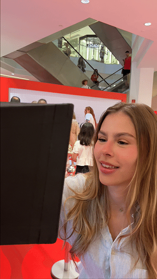 Participantes interagem com ativação Câmera Sign durante a inauguração da loja H&M no Shopping Rio Sul, criando vídeos personalizados com assinatura digital diretamente na lente da câmera.