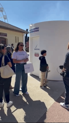 Participante grava vídeo estilo confessionário dentro de estrutura cenográfica da Sensodyne, com tela touch e sistema Phygital que exibe frases em tempo real em uma Social Wall externa durante o Festival de Inverno de Campos do Jordão.