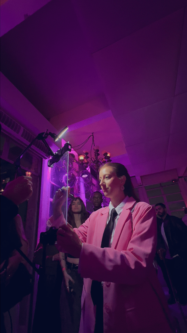 Participante interage com o Roaming Booth da Phygital Solutions durante o evento de 15 anos do Instagram em São Paulo, assinando digitalmente seu vídeo personalizado logo após a captura, em uma experiência que une tecnologia e expressão criativa.