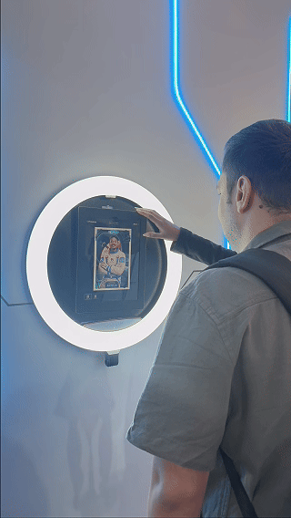 Participantes utilizam a ativação AI Booth no estande da Sabesp durante a SP Innovation Week 2026, realizando capturas fotográficas transformadas por inteligência artificial com impressão instantânea e conteúdos personalizados.