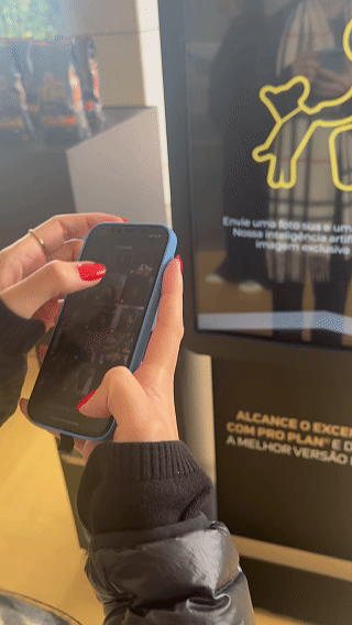 Totem interativo da ativação Nestlé Purina com QR Code para envio de fotos pelo celular. A experiência utilizava inteligência artificial para gerar uma imagem personalizada do tutor ao lado do seu pet, com resultado final direcionado para impressão.