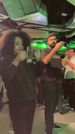 Equipe Phygital fotografa participantes no espaço da Jameson, entregando fotos impressas em estilo polaroid como lembrança da ativação.