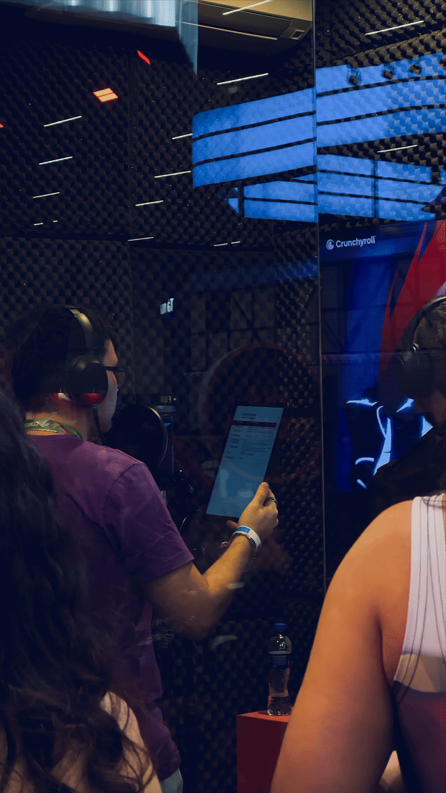 Fãs participam da experiência de dublagem anime no estande da Crunchyroll na CCXP