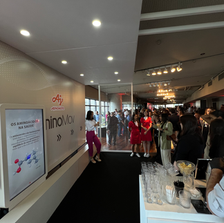 Participantes interagem com a tela Raio X da Phygital Solutions no evento de lançamento do AminoMov da Ajinomoto, explorando de forma dinâmica os benefícios do suplemento.
