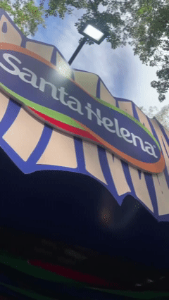 Participante tira foto no AI Booth da Santa Helena durante a Festa Junina do Clube Pinheiros e recebe imagem impressa no estilo Cordel.