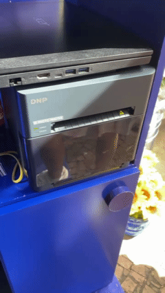 Participante tira foto no AI Booth da Santa Helena durante a Festa Junina do Clube Pinheiros e recebe imagem impressa no estilo Cordel.