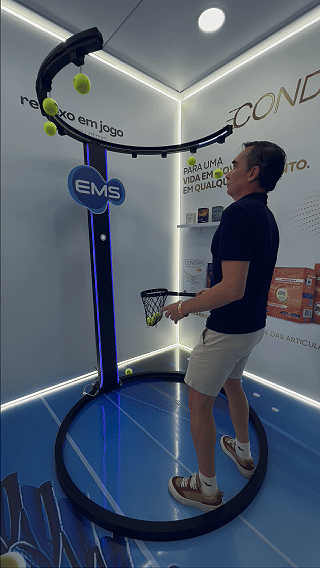Ativação Reaction Ring no espaço da EMS durante o RIO OPEN 2026, com participante dentro da estrutura semicircular interativa enquanto o público acompanha ao redor em ambiente de evento esportivo.