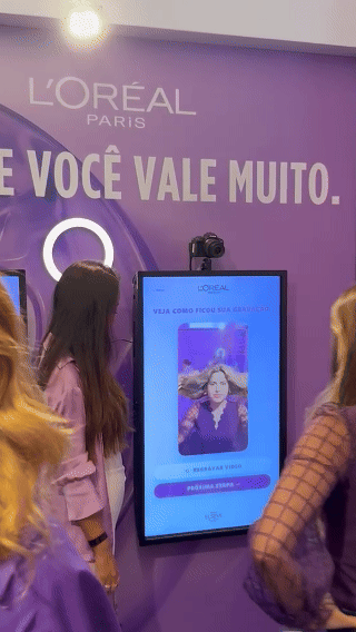 Ativação interativa da L’Oréal com totem digital capturando vídeo em slow motion para registrar transformação de cabelo durante experiência em shopping.