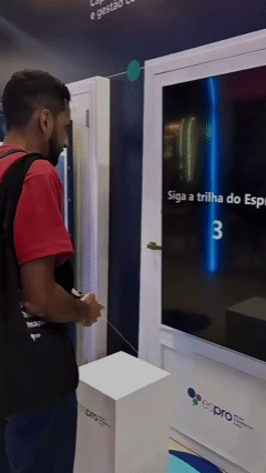 Participantes jogam game interativo inspirado em Pacman no estande da Espro durante o CONARH 2025. A ativação, criada pela Phygital Solutions em parceria com a agência Beez, permitia escolha de avatar, cenários e promovia engajamento com propósito.